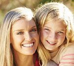 A woman and girl smiling for the camera.