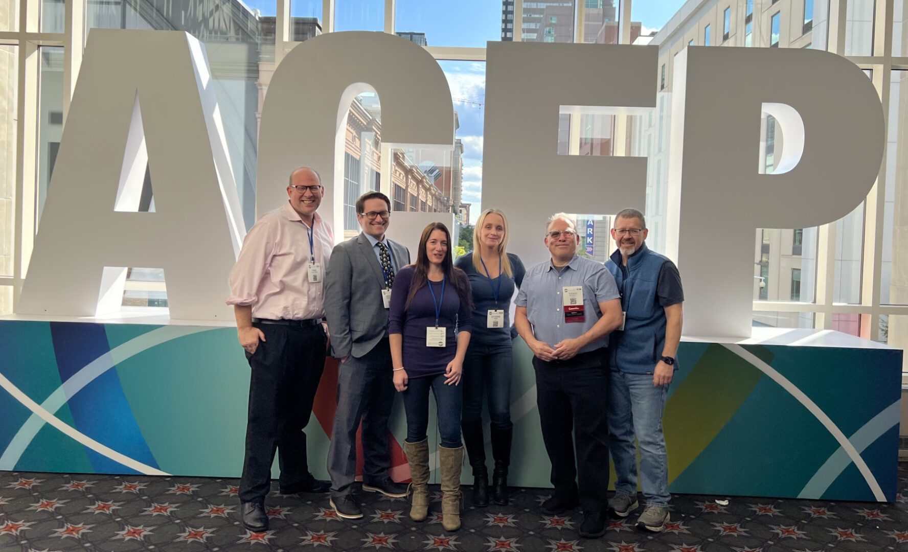 A bunch of people standing in front of acep logo